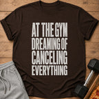 Brown t-shirt with white text that reads "AT THE GYM DREAMING OF CANCELING EVERYTHING."