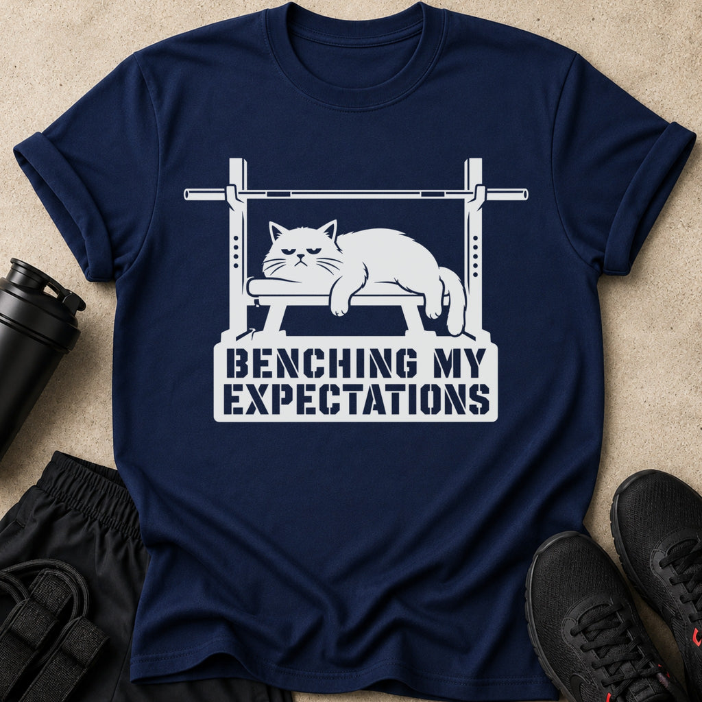 Navy t-shirt with a white graphic of a cat on a bench press. Text says "BENCHING MY EXPECTATIONS".