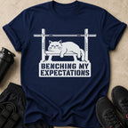 Navy t-shirt with a white graphic of a cat on a bench press. Text says "BENCHING MY EXPECTATIONS".