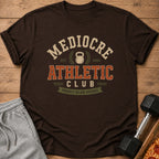 Brown t-shirt with "Mediocre Athletic Club" and kettlebell graphic.