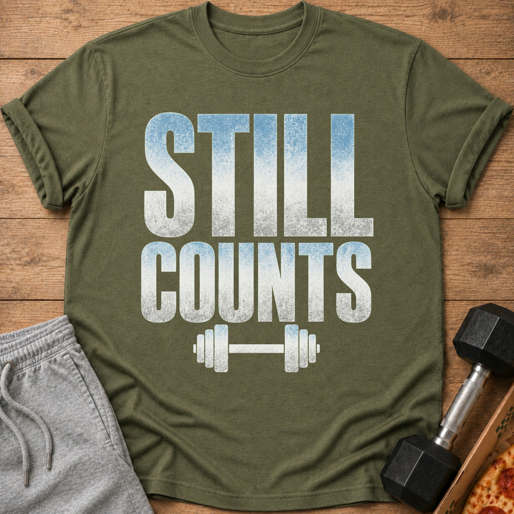 Olive green t-shirt with "STILL COUNTS" text and a dumbbell graphic.