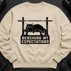 Black cat on weight bench graphic with text "BENCHING MY EXPECTATIONS".