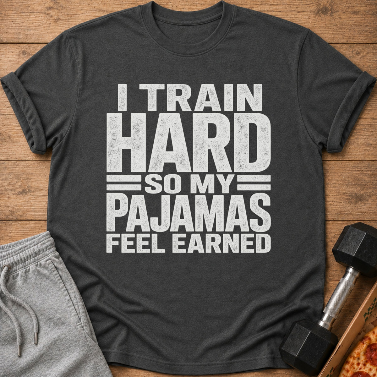 Dark gray t-shirt with white text: "I TRAIN HARD SO MY PAJAMAS FEEL EARNED".