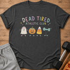 A dark gray t-shirt with the text Dead Tired Athletic Club and cartoon Halloween characters exercising.