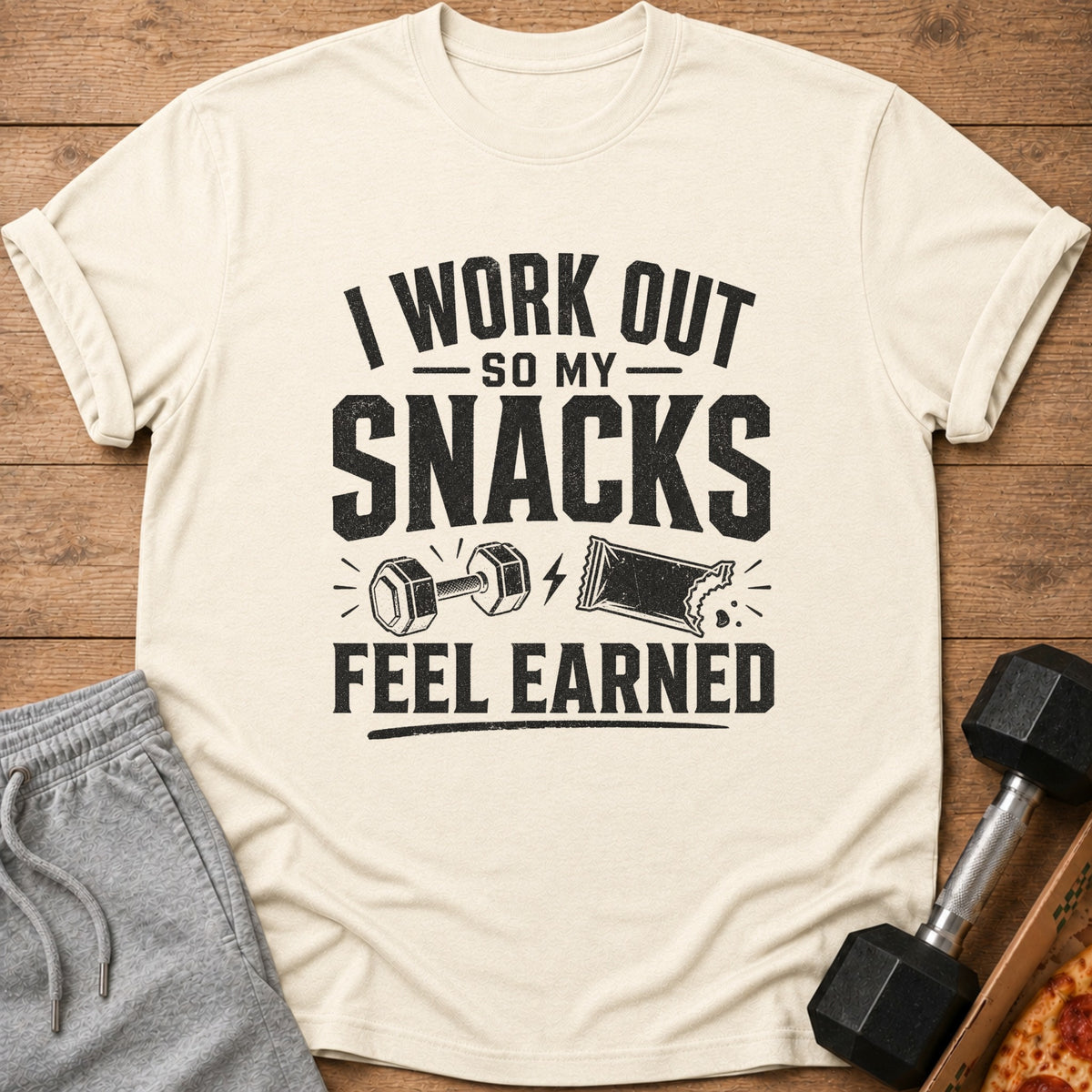 Cream t-shirt with black text "I WORK OUT SO MY SNACKS FEEL EARNED".