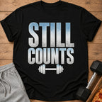 Black t-shirt with "STILL COUNTS" text and dumbbell graphic.