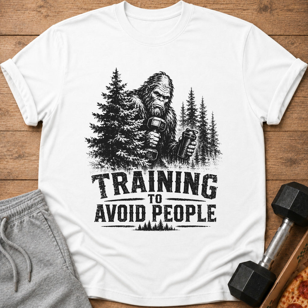 Bigfoot lifting weights with text "TRAINING TO AVOID PEOPLE" on a white shirt.
