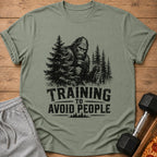 Bigfoot holding dumbbells and shaker bottle with text "TRAINING TO AVOID PEOPLE".