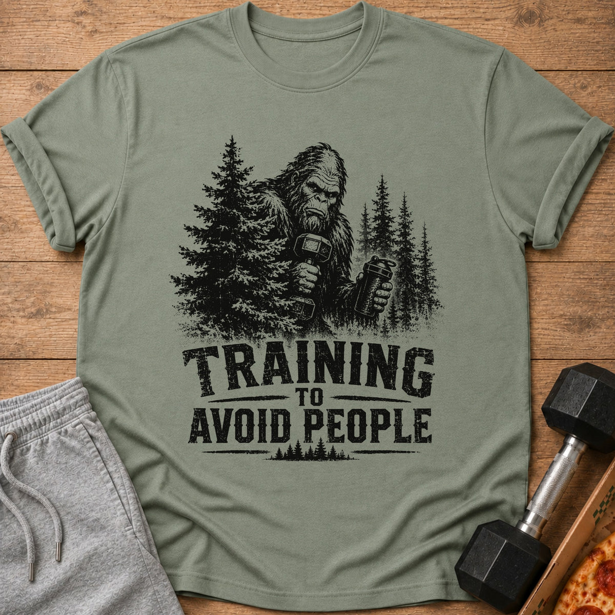 Bigfoot holding dumbbells and shaker bottle with text "TRAINING TO AVOID PEOPLE".
