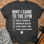 Dark gray t-shirt with "Why I Came to the Gym" list including build strength, maintain health, earn couch time.