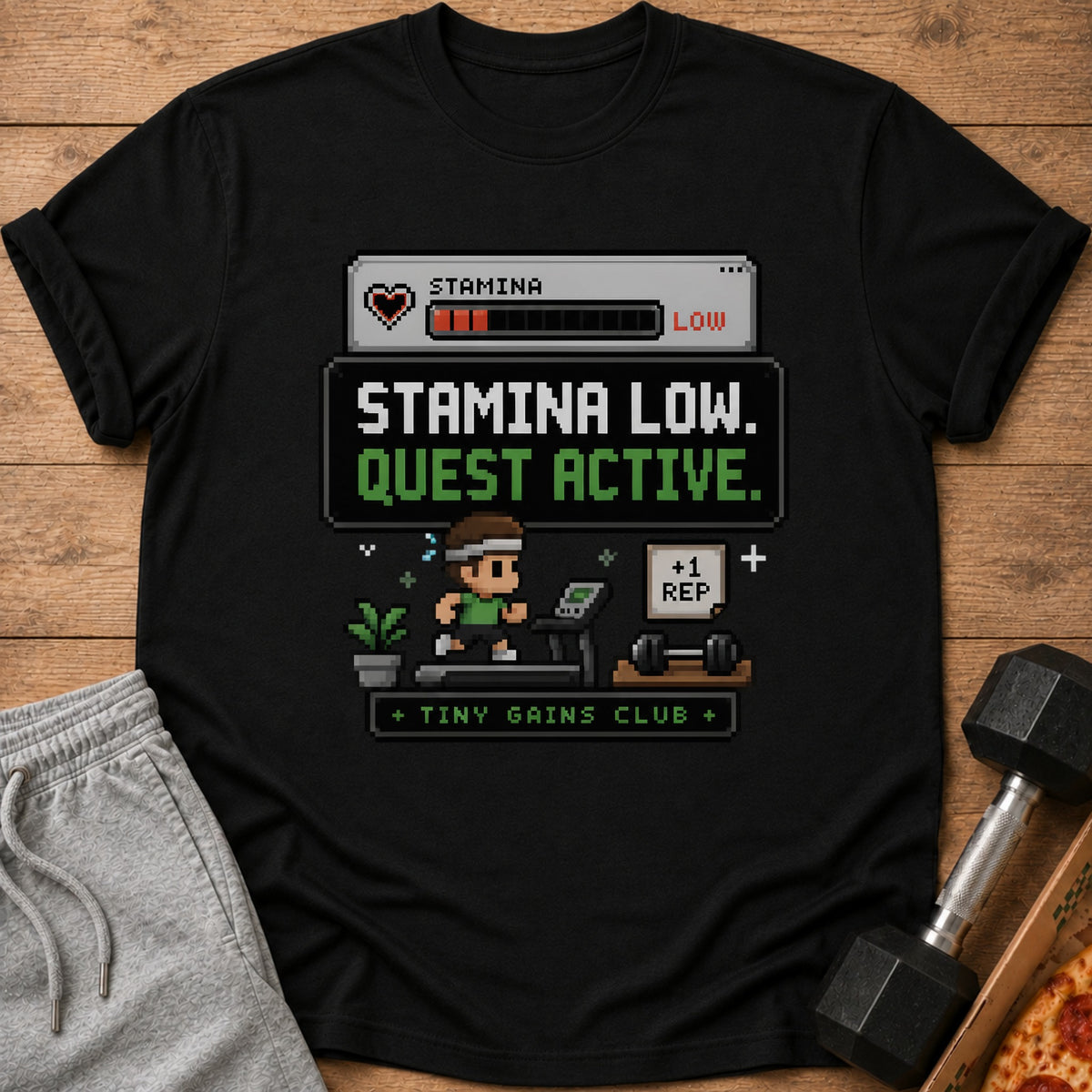 Black t-shirt with pixelated "Stamina Low. Quest Active." and gym graphics.