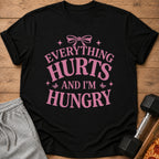 Black t-shirt with pink text that reads "Everything Hurts and I'm Hungry".