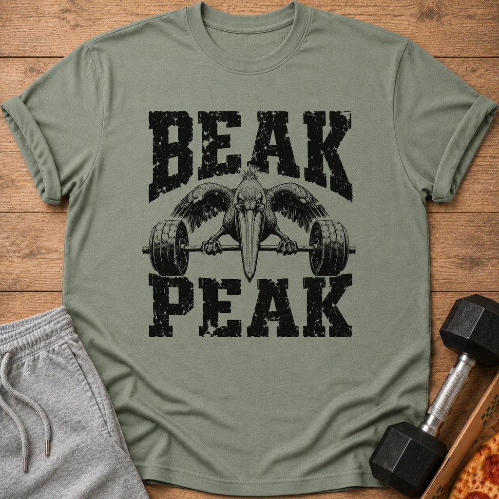 An olive green t-shirt with a graphic of a pelican lifting a barbell and the text Beak Peak.