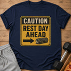 Navy t-shirt with "CAUTION REST DAY AHEAD" warning sign graphic and foam roller.