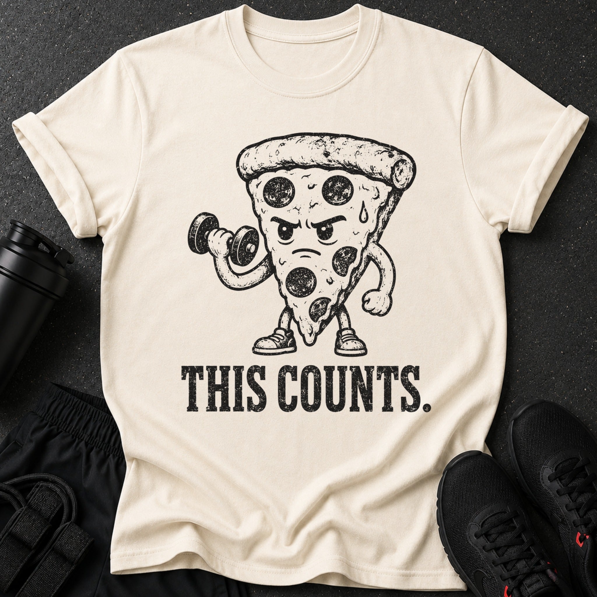 Cream t-shirt with cartoon pizza lifting dumbbell and text "THIS COUNTS."