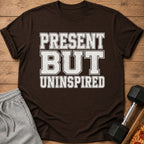 Brown t-shirt with distressed text "PRESENT BUT UNINSPIRED" and a dumbbell and pizza slice.