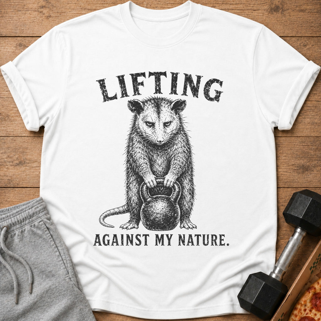 White t-shirt with possum lifting kettlebell and text "Lifting Against My Nature."