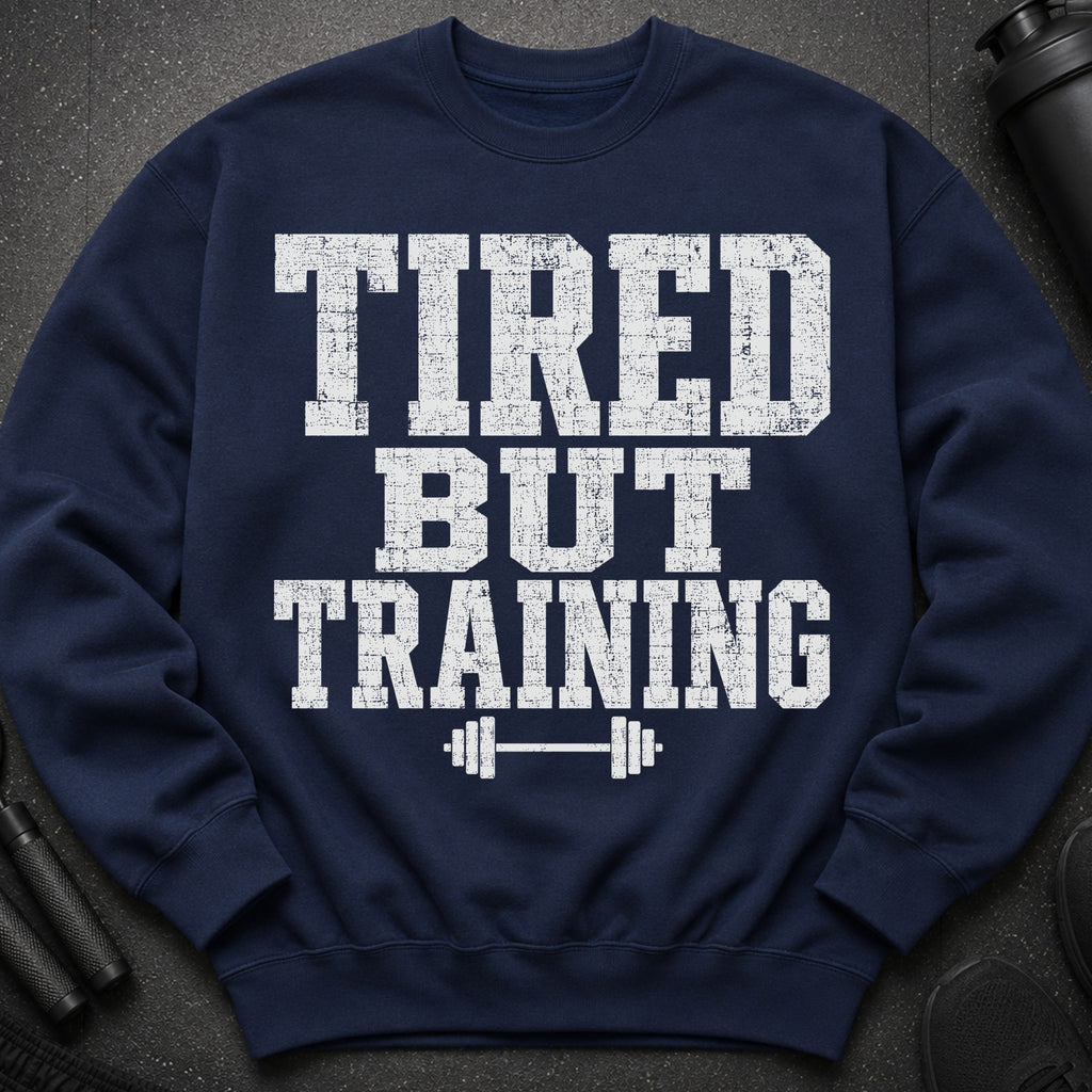 Navy sweatshirt with distressed white text "TIRED BUT TRAINING" and barbell graphic.