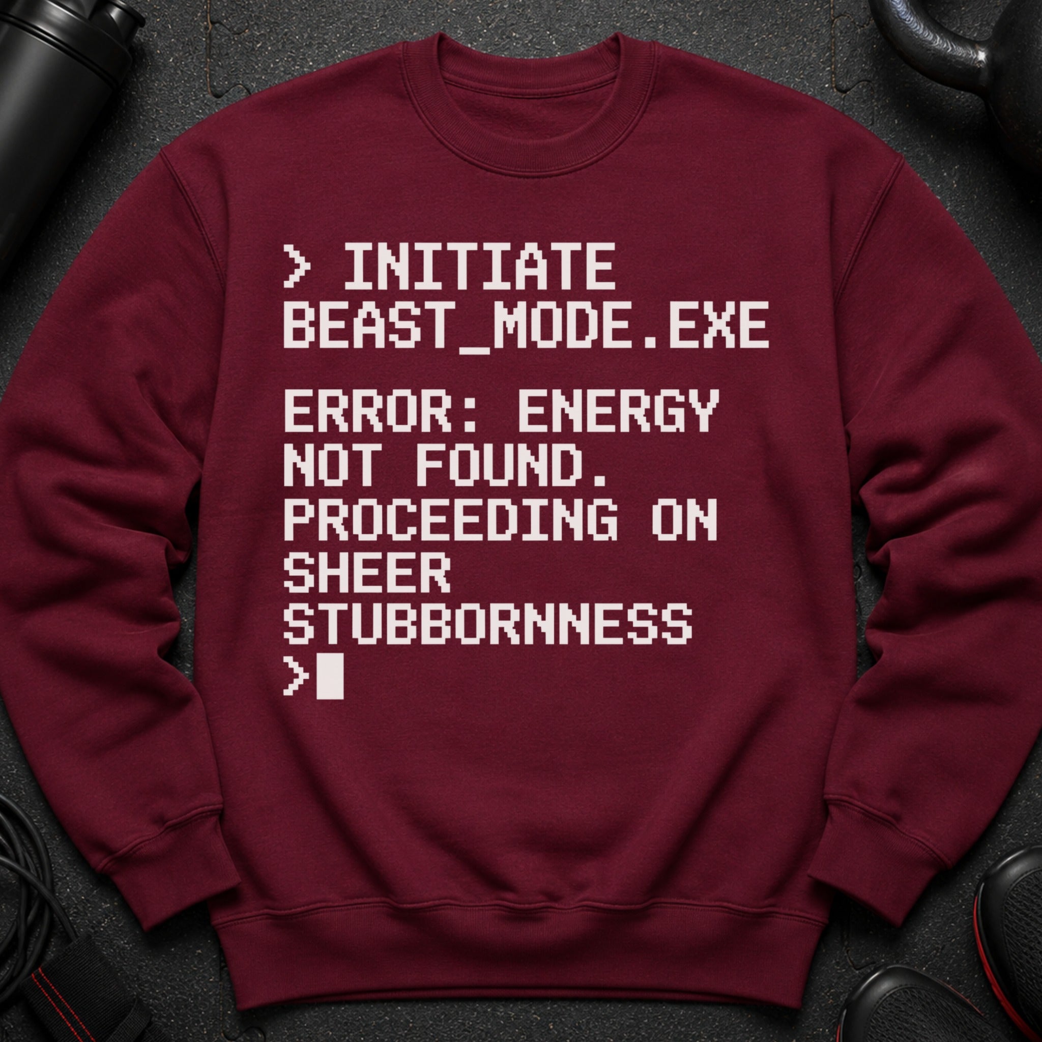 Maroon sweatshirt with white text: "INITIATE BEAST_MODE.EXE ERROR: ENERGY NOT FOUND. PROCEEDING ON SHEER STUBBORNNESS >"