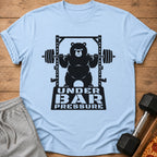 Light blue t-shirt with a black graphic of a bear lifting weights, text "UNDER BAR PRESSURE".