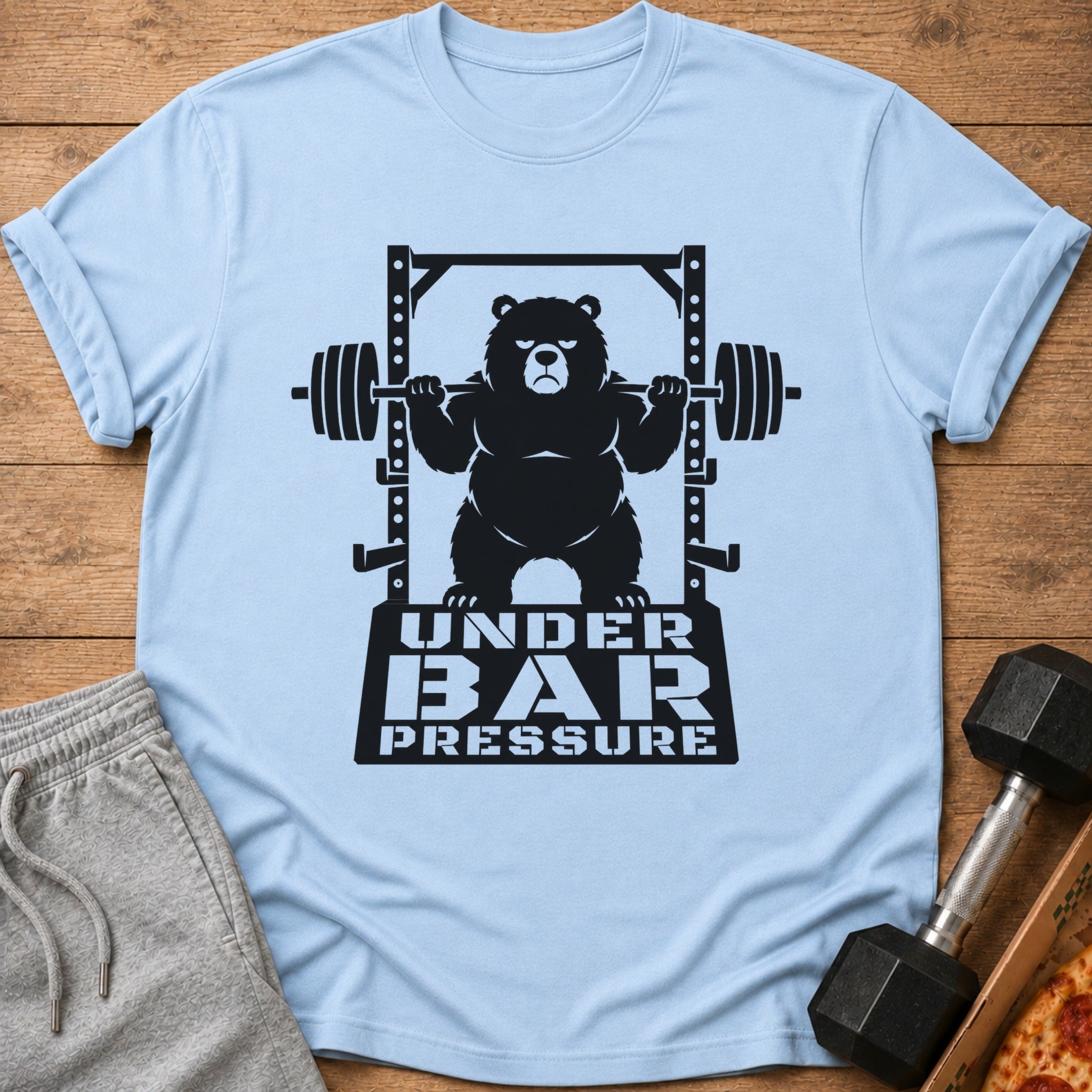Light blue t-shirt with a black graphic of a bear lifting weights, text "UNDER BAR PRESSURE".