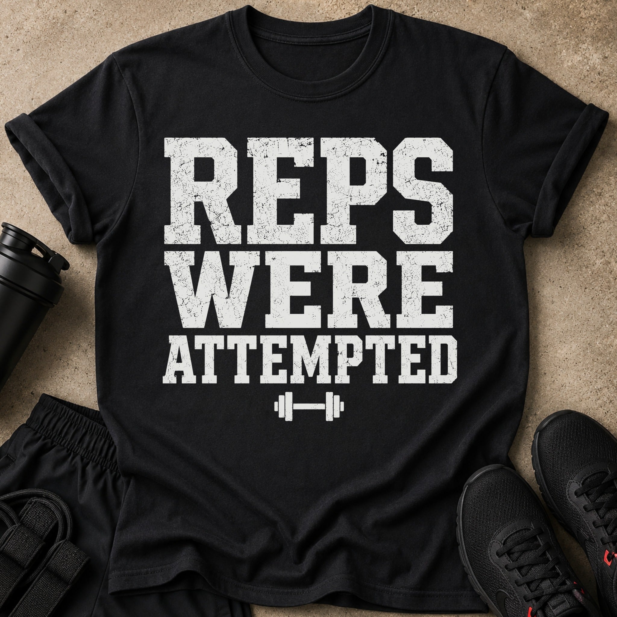 Black t-shirt with "REPS WERE ATTEMPTED" text and a dumbbell graphic.
