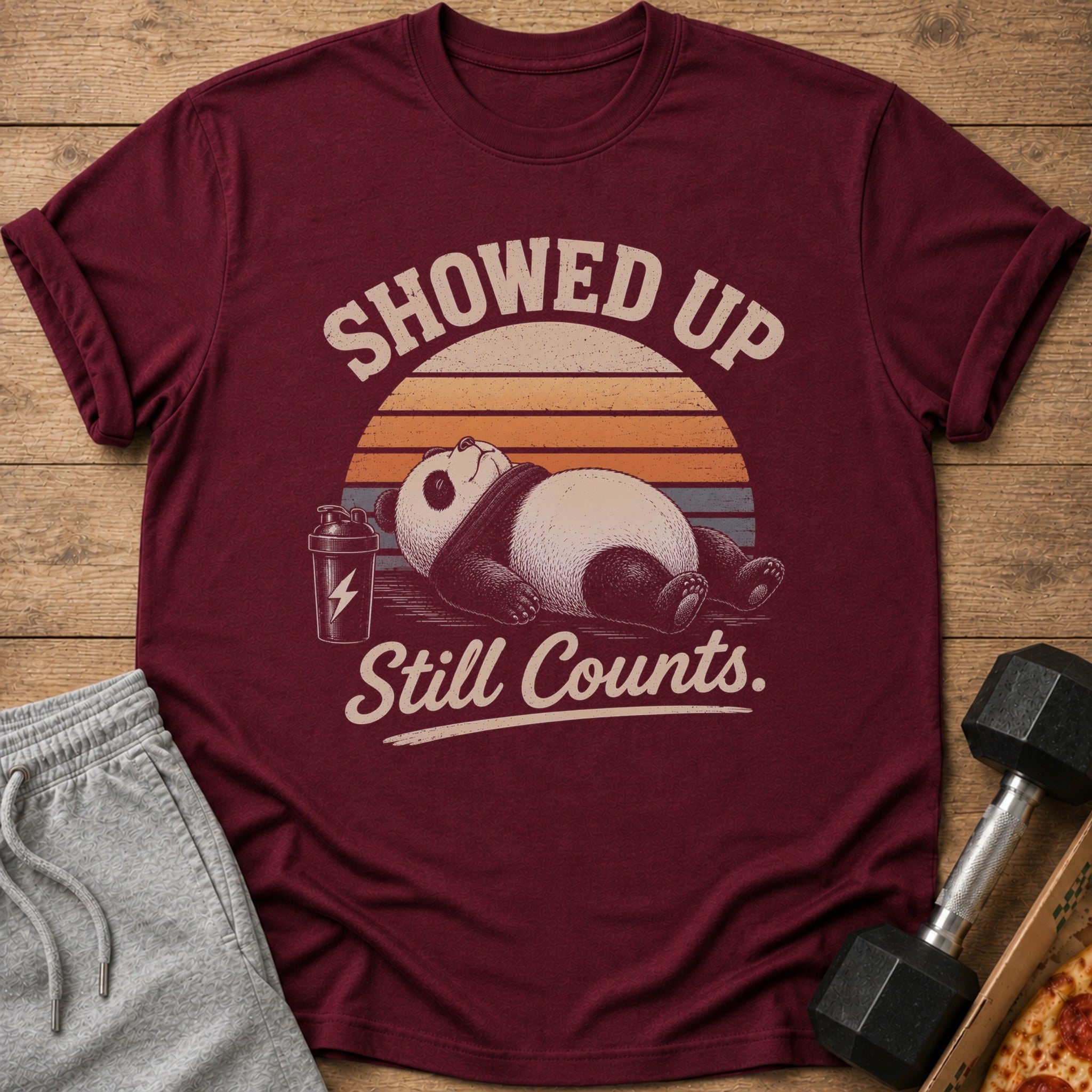 Maroon t-shirt with a panda graphic and text "Showed Up Still Counts."