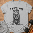 Gray t-shirt with opossum graphic and text "LIFTING AGAINST MY NATURE".