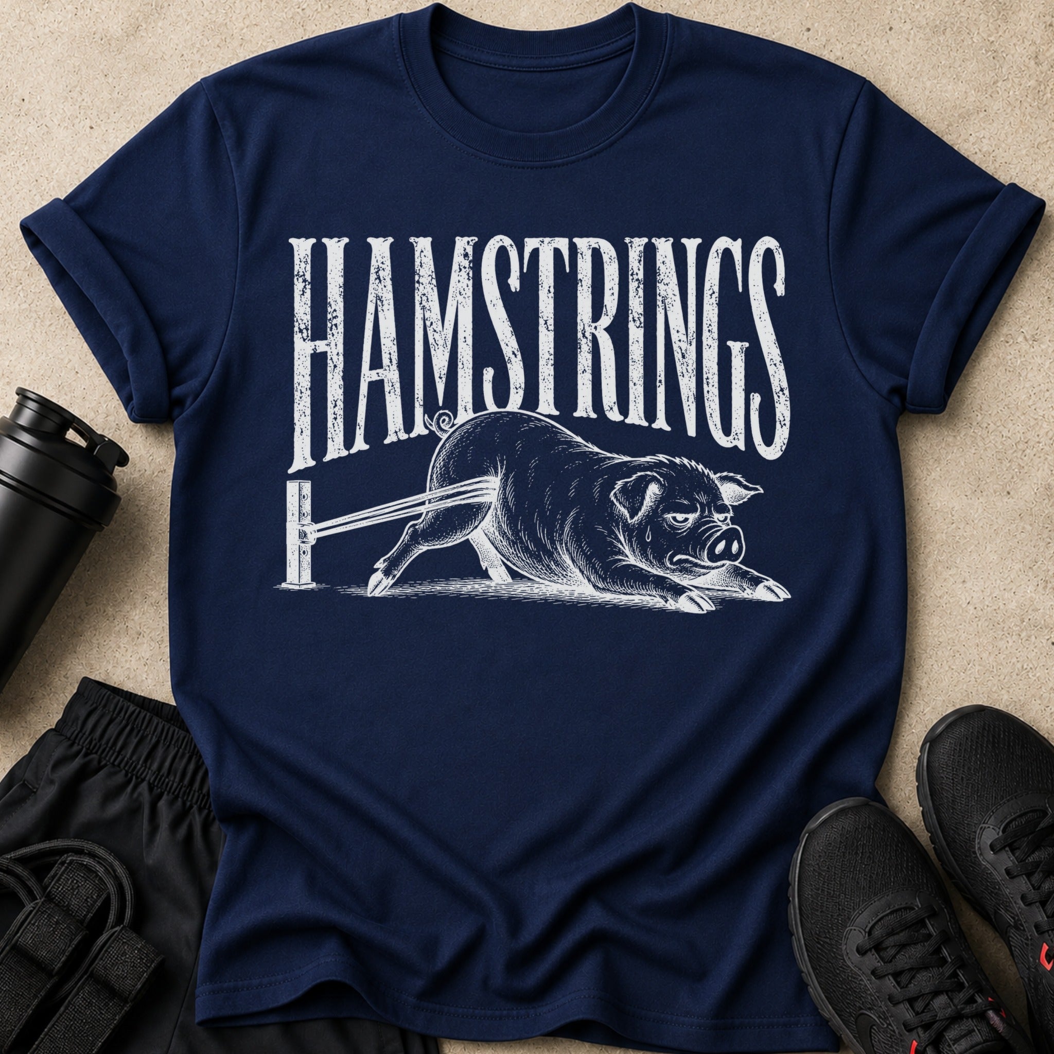Navy t-shirt with white text "HAMSTRINGS" and a pig struggling on a bar.