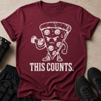 Maroon t-shirt with white graphic of pizza slice lifting dumbbell and text "THIS COUNTS."