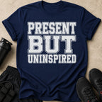 Navy t-shirt with white distressed text reading "PRESENT BUT UNINSPIRED".