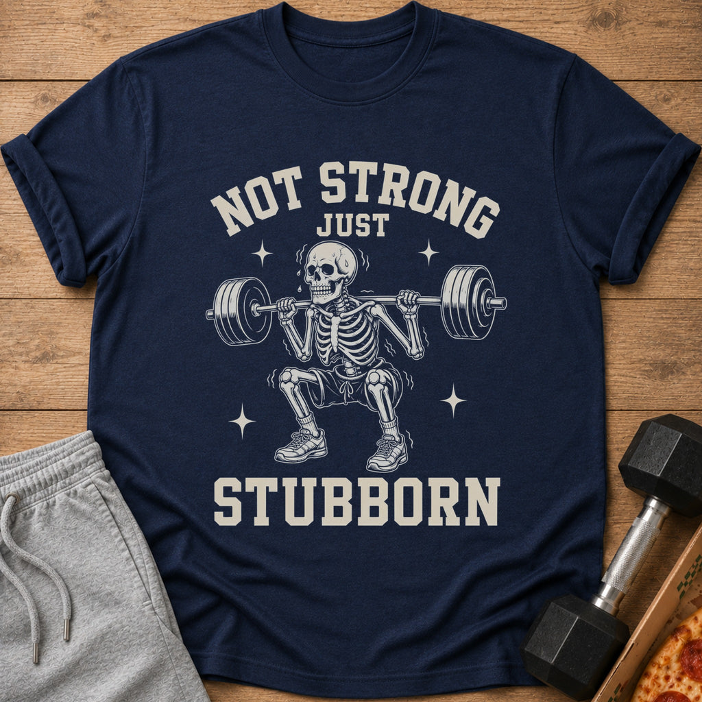 Navy t-shirt with skeleton squatting barbell, text "NOT STRONG JUST STUBBORN".