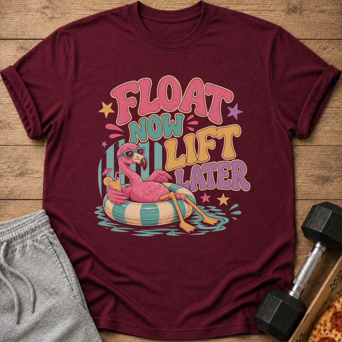 Maroon t-shirt with "Float Now Lift Later" text and a flamingo on a float.