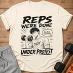 Cream t-shirt with manga-style graphic: "REPS WERE DONE" and "UNDER PROTEST".