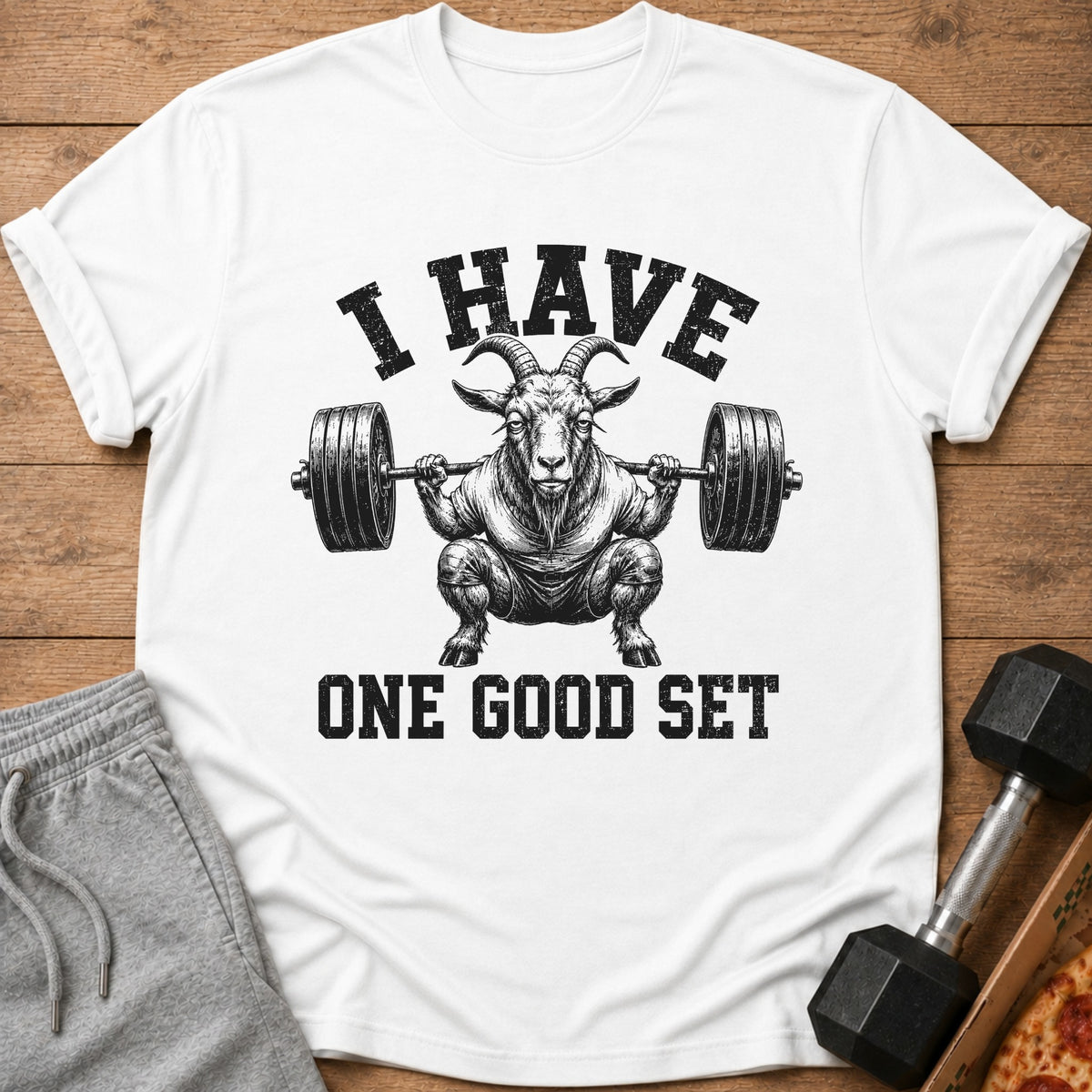 White t-shirt with graphic of a goat lifting weights and text "I HAVE ONE GOOD SET."