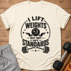 Cream t-shirt with "I lift weights but not my standards" graphic and broken barbell.