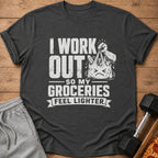 Dark gray t-shirt with white text "I work out so my groceries feel lighter" and cartoon grocery bag.