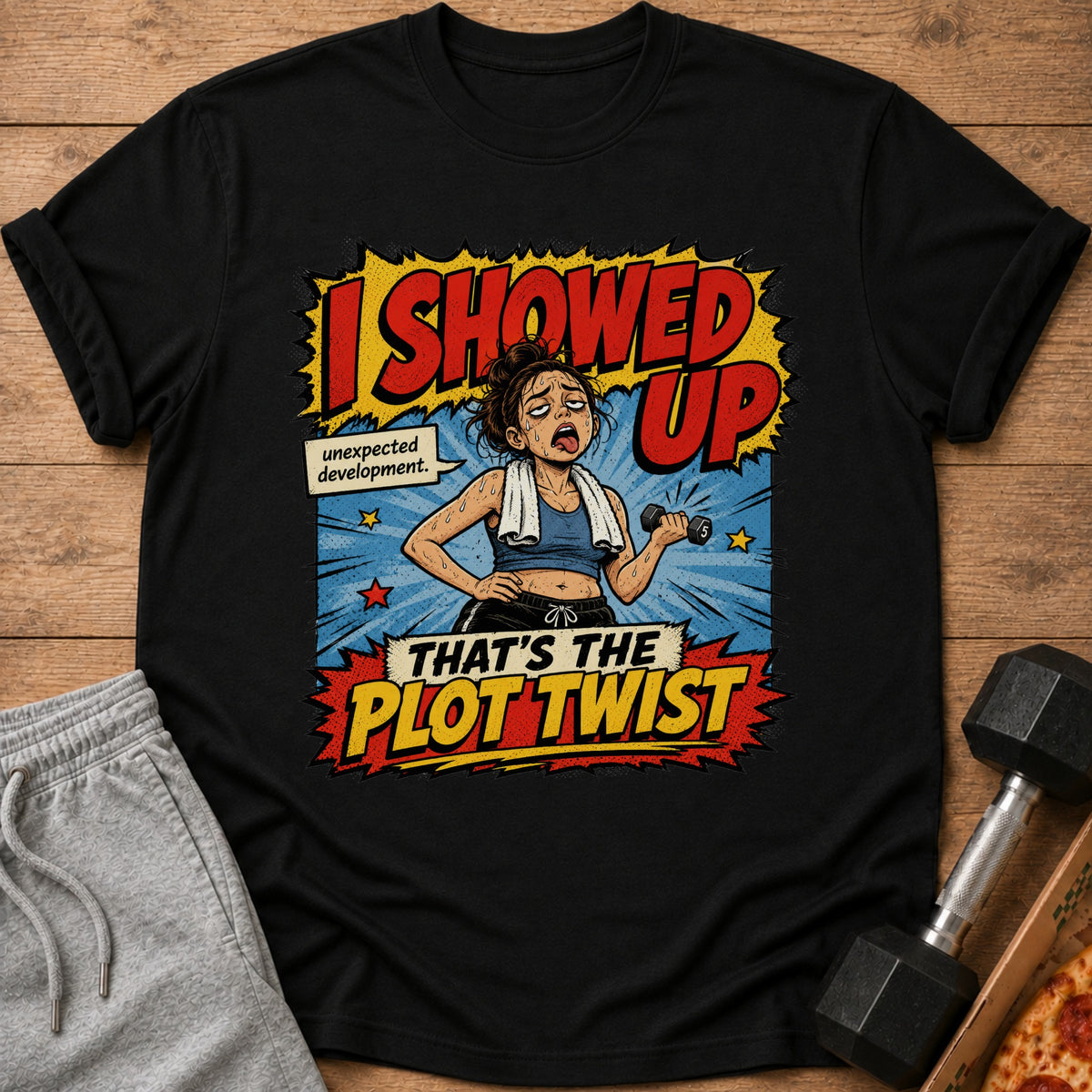 Graphic tee with cartoon woman lifting dumbbell, text "I showed up. Unexpected development. That's the plot twist."