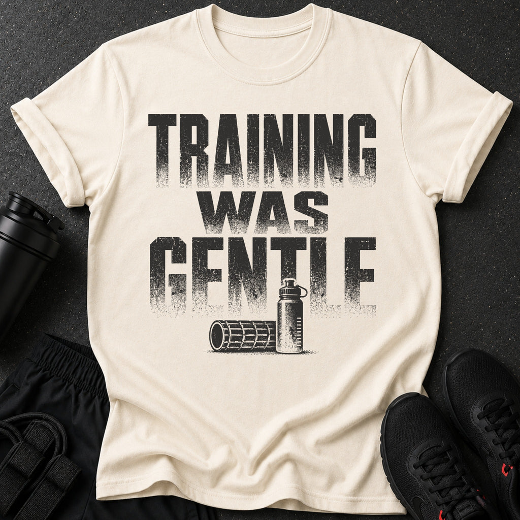 Cream t-shirt with distressed black text "TRAINING WAS GENTLE" and fitness accessories.