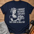 Navy t-shirt with vintage woman holding cupcakes, text says "I BROUGHT RECOVERY CUPCAKES THEY COUNT AS MEAL PREP".