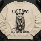 Opossum lifting a kettlebell, text: "LIFTING AGAINST MY NATURE."