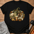 Black t-shirt with a pumpkin design made of dumbbells, snacks, headphones, and a game controller.