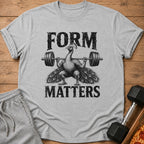 Grey t-shirt with a black graphic of a peacock lifting weights and text "FORM MATTERS".