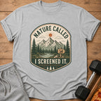 Grey t-shirt with a graphic of mountains, trees, and the text "NATURE CALLED I SCREENED IT."