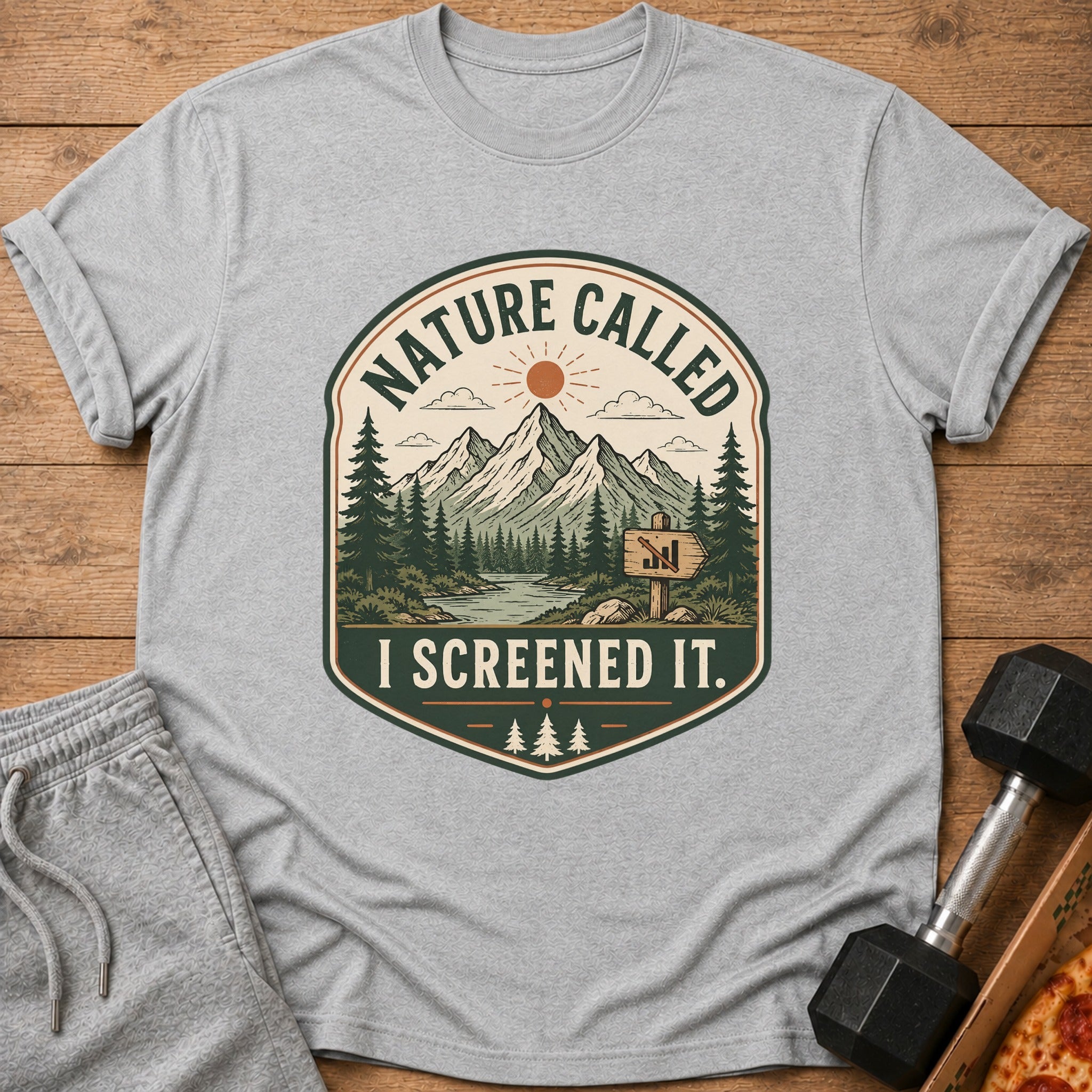 Grey t-shirt with a graphic of mountains, trees, and the text "NATURE CALLED I SCREENED IT."