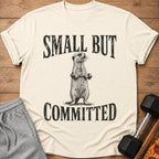 T-shirt with a meerkat lifting weights and the text "SMALL BUT COMMITTED".