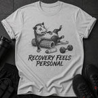 T-shirt with opossum on foam roller and dumbbell, text reads "Recovery Feels Personal".