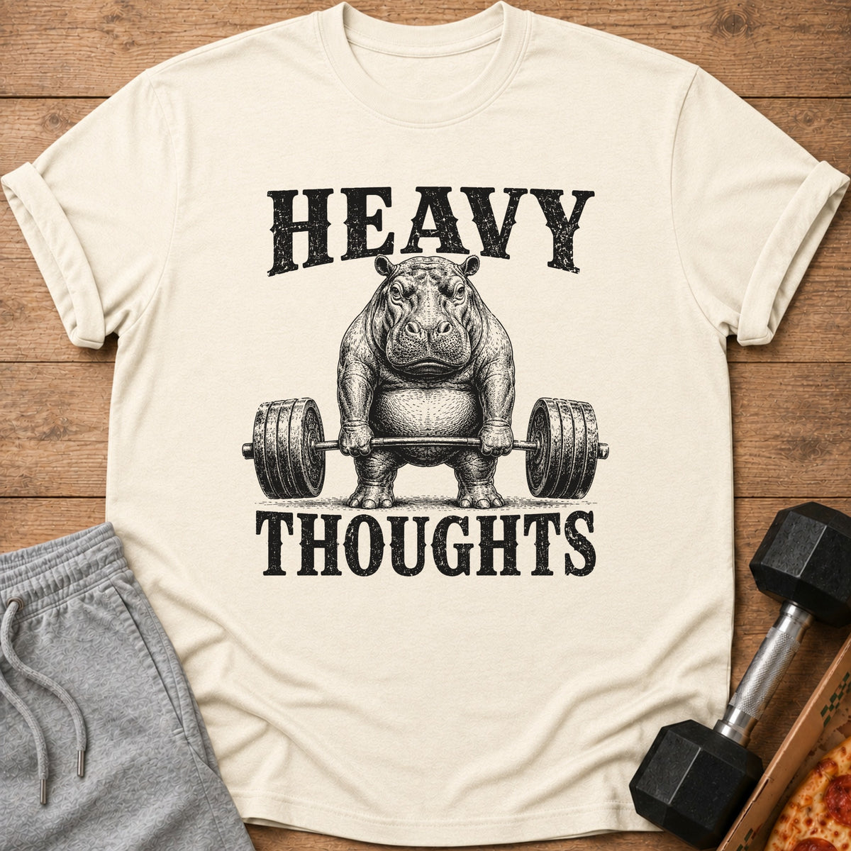 T-shirt with a vintage-style hippo lifting a barbell, text reads "HEAVY THOUGHTS".