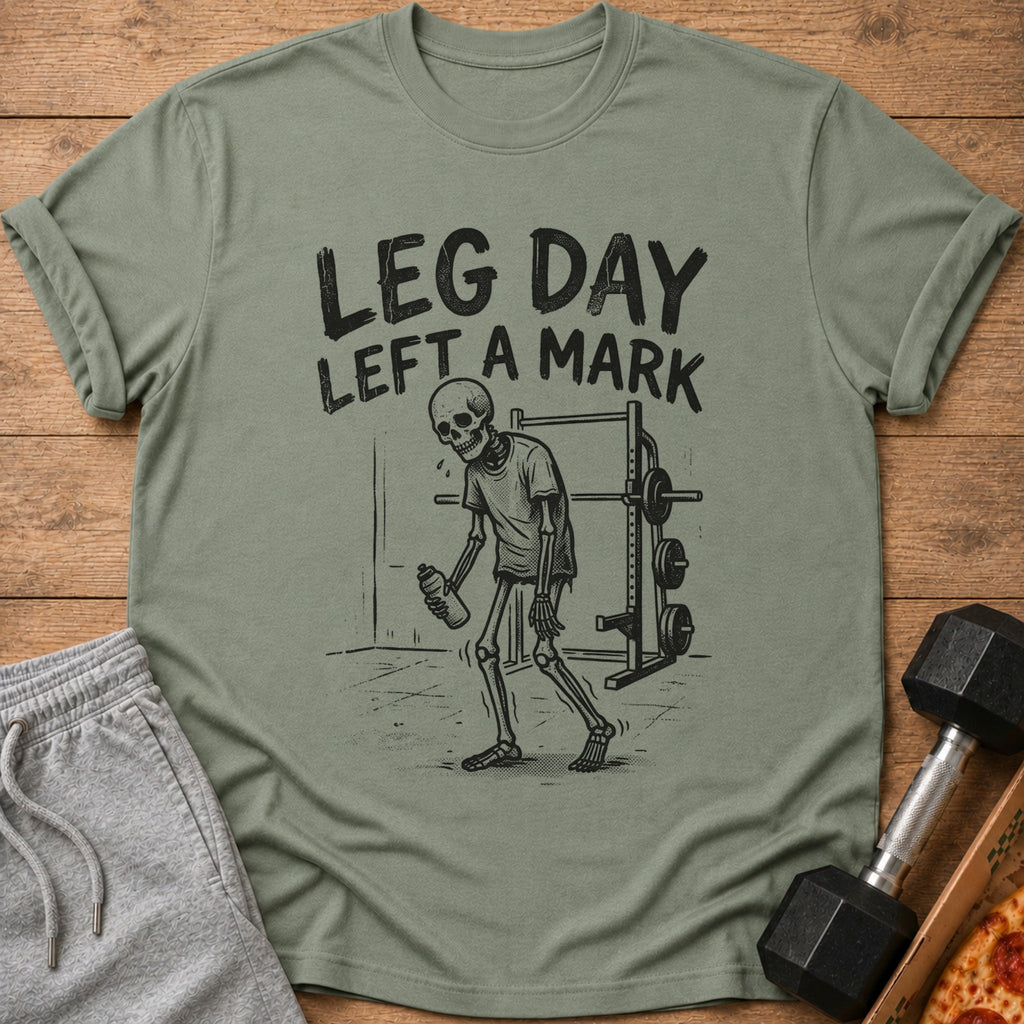 T-shirt with skeleton holding water bottle, gym equipment, and text "LEG DAY LEFT A MARK."