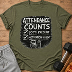 Green t-shirt with "Attendance Counts: Body Present, Motivation Absent" text, kettlebell, and shaker cup.